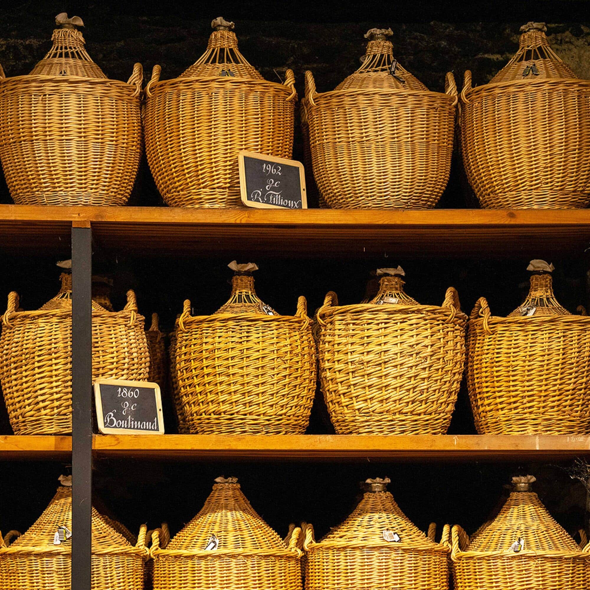 Demi-johns on shelves in one of our oldest cellars, containing very old eaux-de-vie