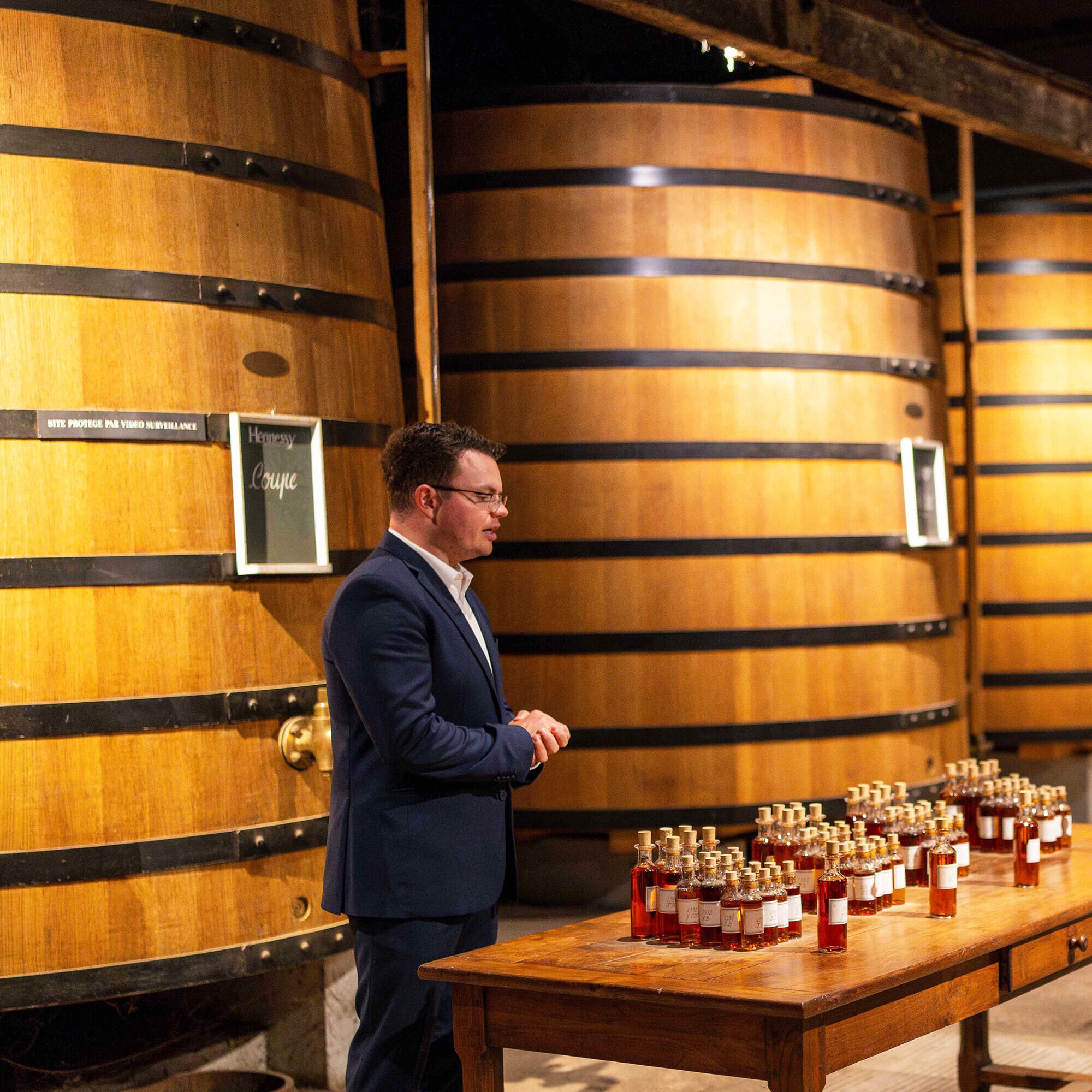 Expert guide in a historical Hennessy cellar, talking about the art of blending
