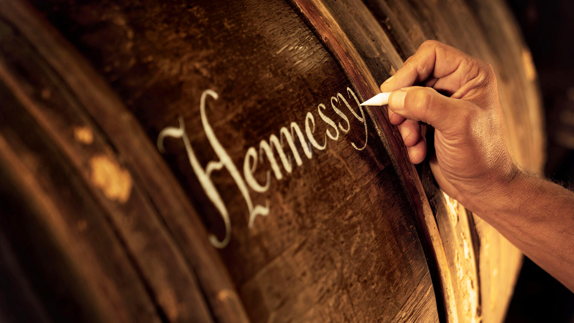 Barrique Hennessy, avec artisan calligraphiant à la craie une inscription sur la barrique selon une technique ancestrale