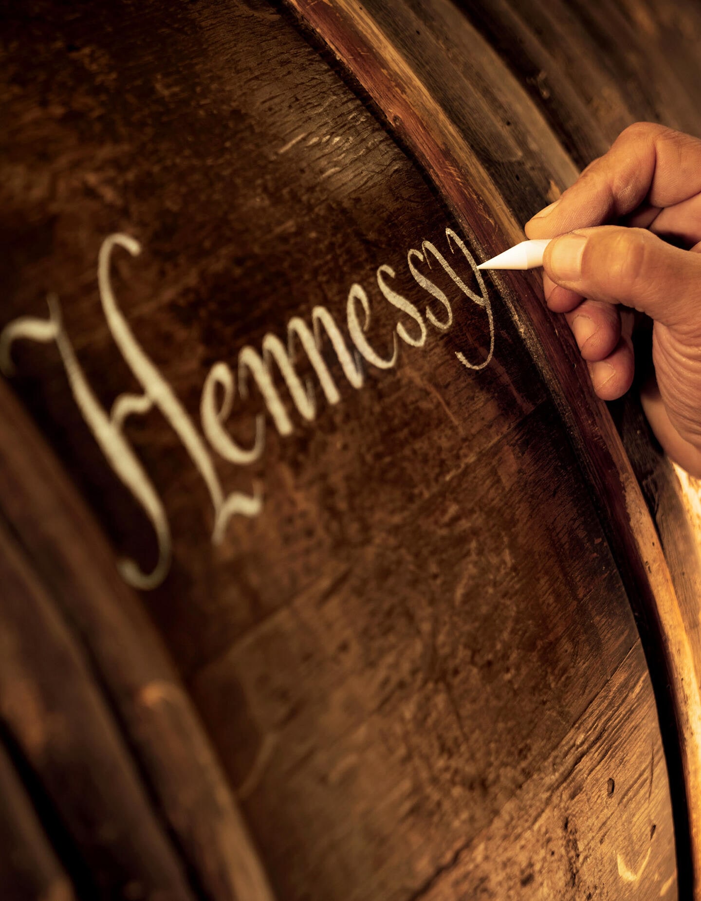 Barrique Hennessy, avec artisan calligraphiant à la craie une inscription sur la barrique selon une technique ancestrale
