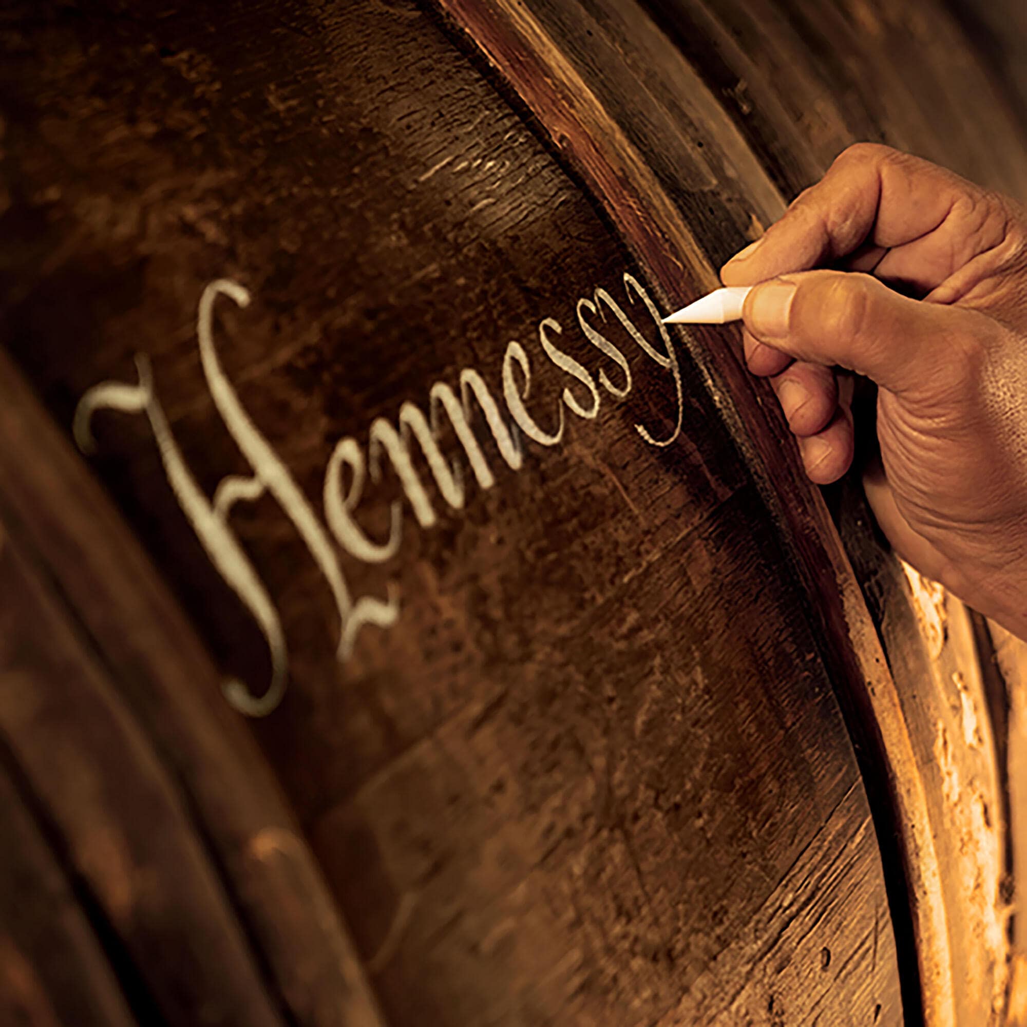 Calligraphie traditionnelle Hennessy, à la craie, sur une barrique en chêne