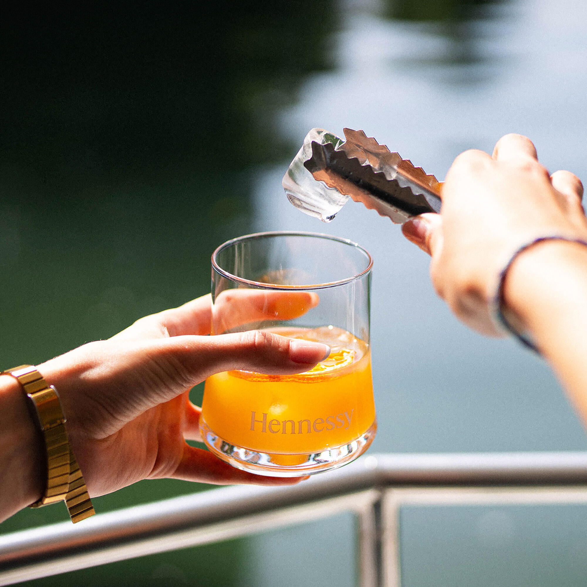 Guide Hennessy ajoutant un glaçon dans un cocktail au cognac Hennessy VSOP, à bord du bateau