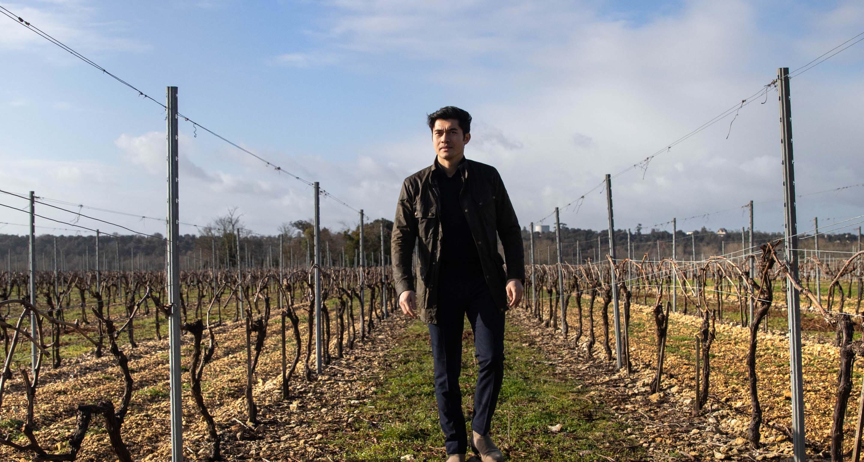 Henry Golding walking through the Hennessy vineyard in Cognac.