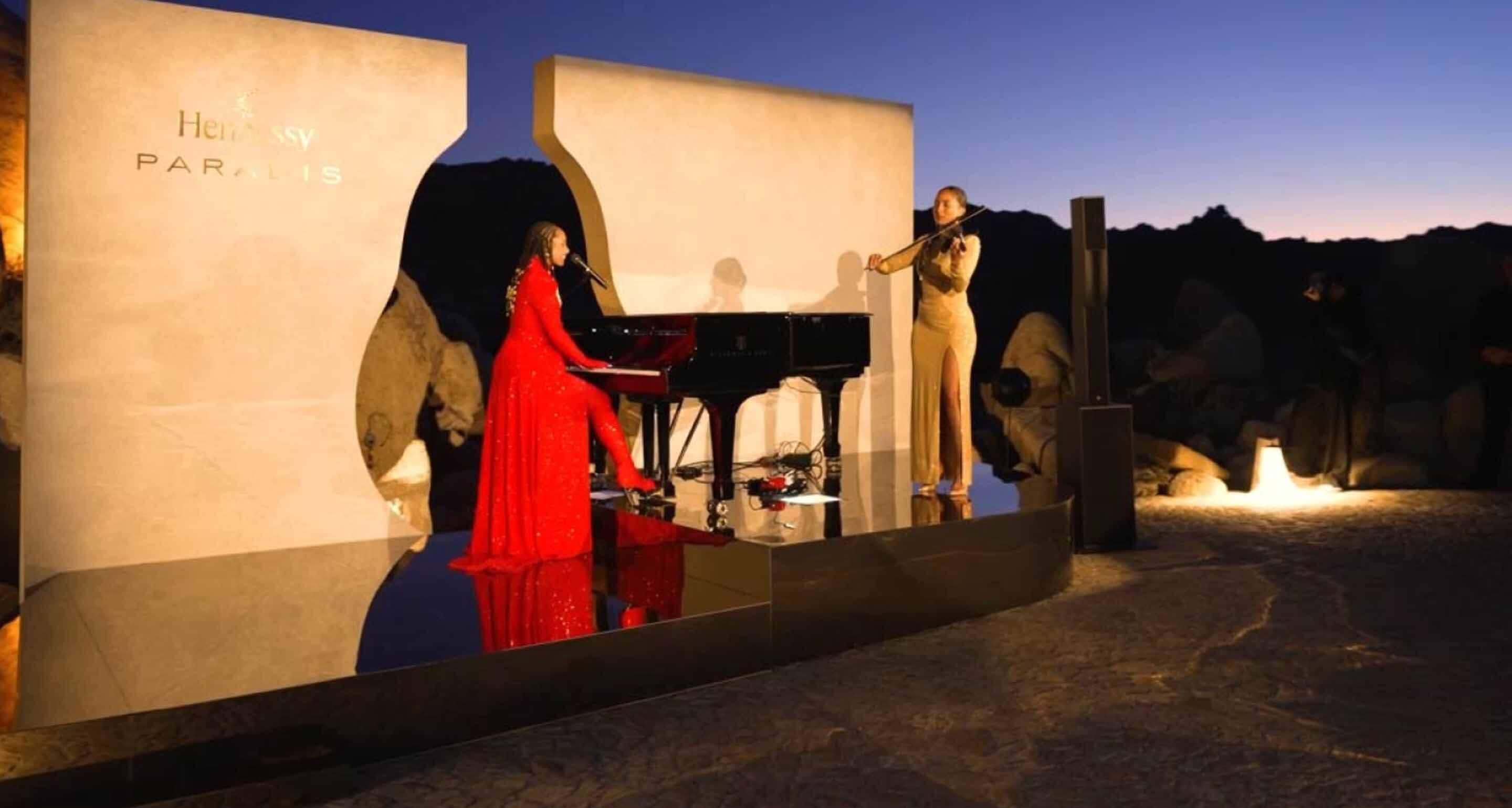 Alicia Keys playing the piano with grace and confidence, accompanied by an artist on the violin.