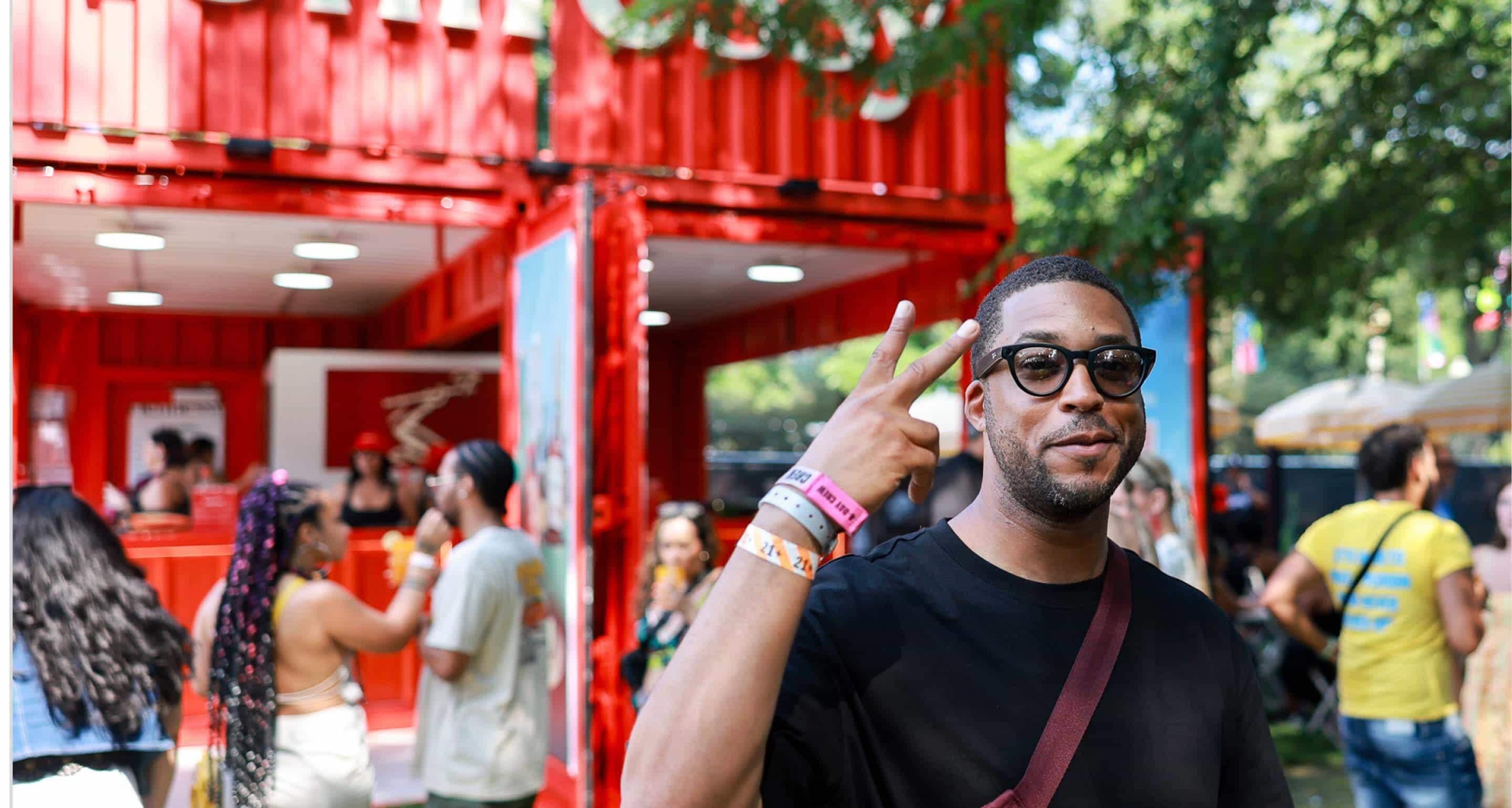 Smiling Hennessy customer posing happily at a lively music festival.