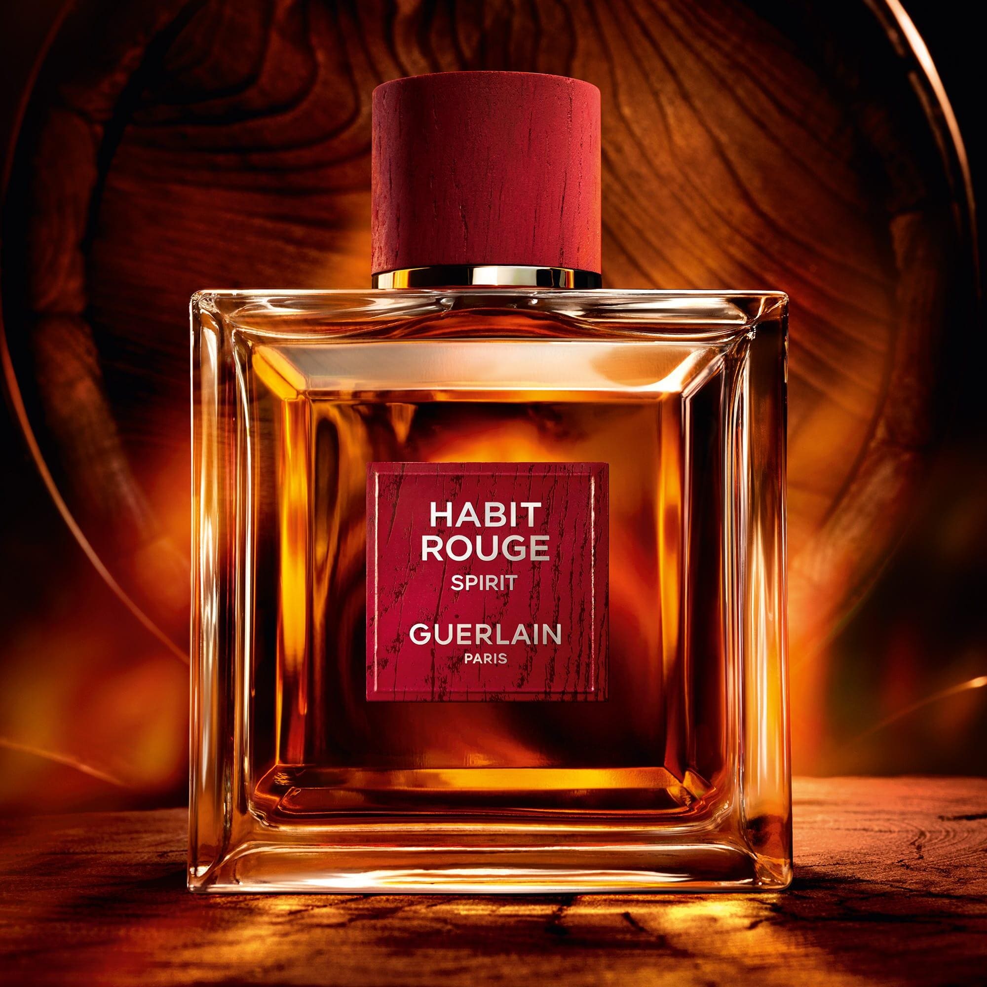Elegant glass perfume bottle filled with an amber-hued fragrance, set against a softly lit background.