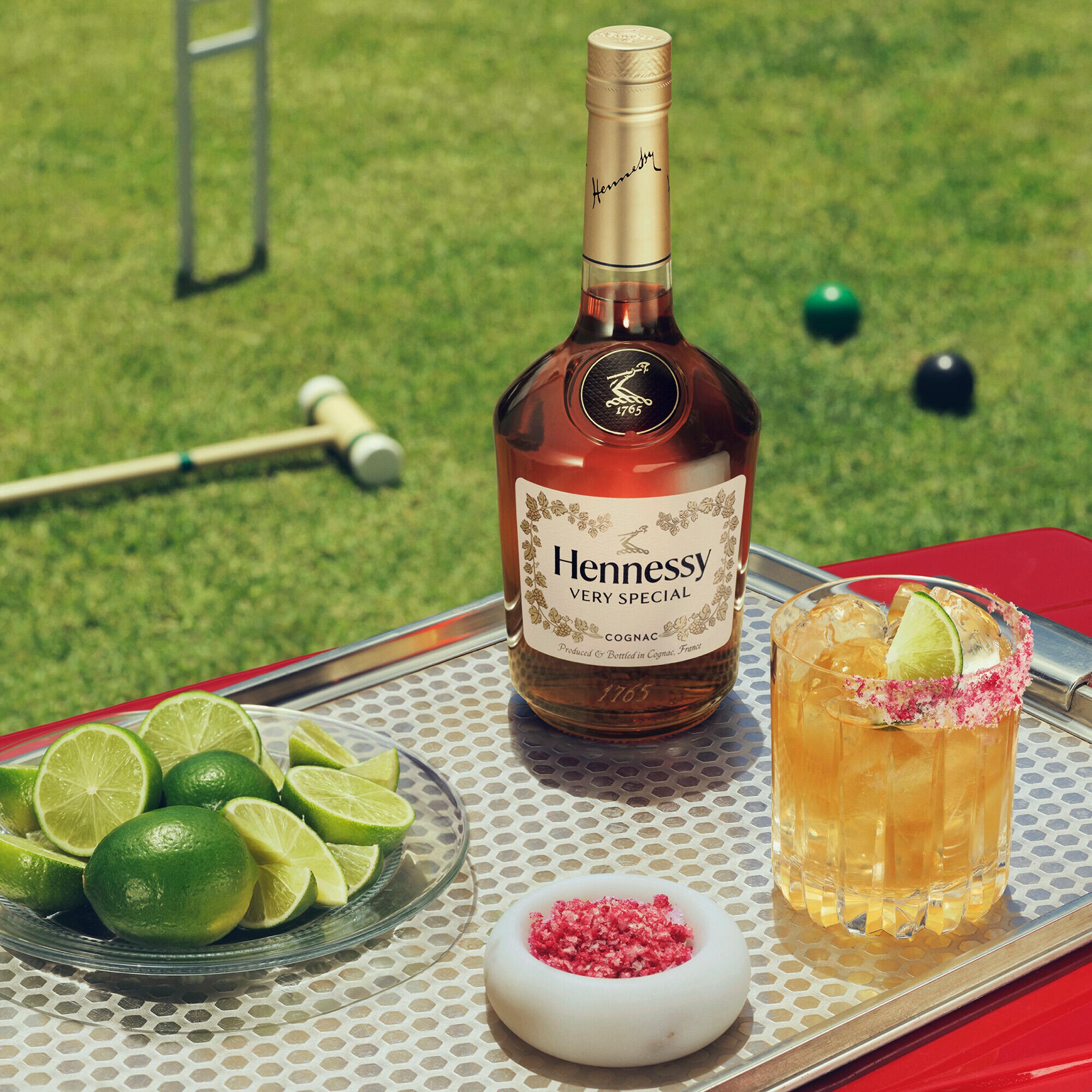Sparkling Hennessy V.S bottle and HENNY RITA™ on a stylish tray set on the lawn.