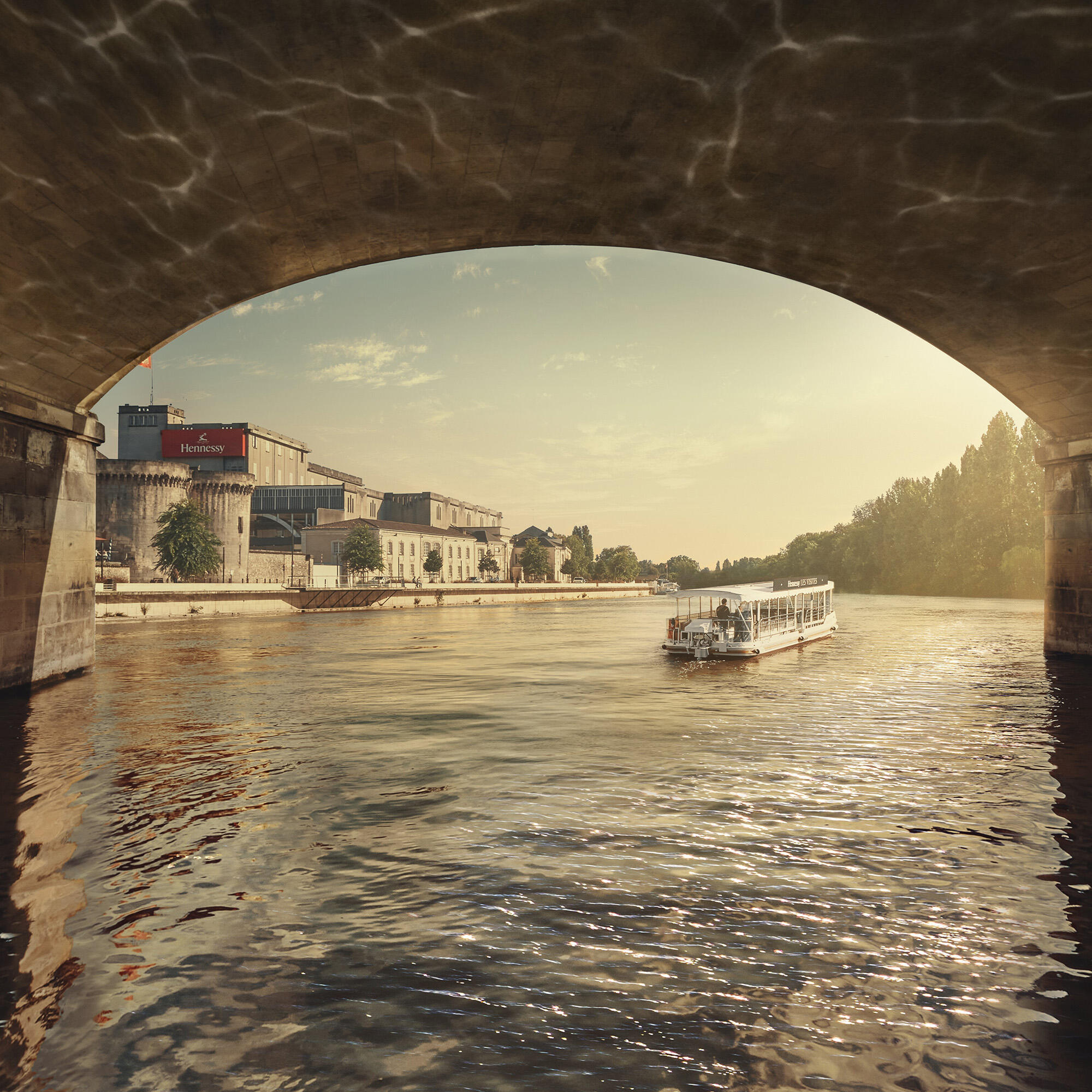 View of the Charente River with a two solar-powered boat from Hennessy Visites